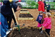 Man and Three Children at Community Garden