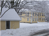 Yellow House and Shed Covered With Snow